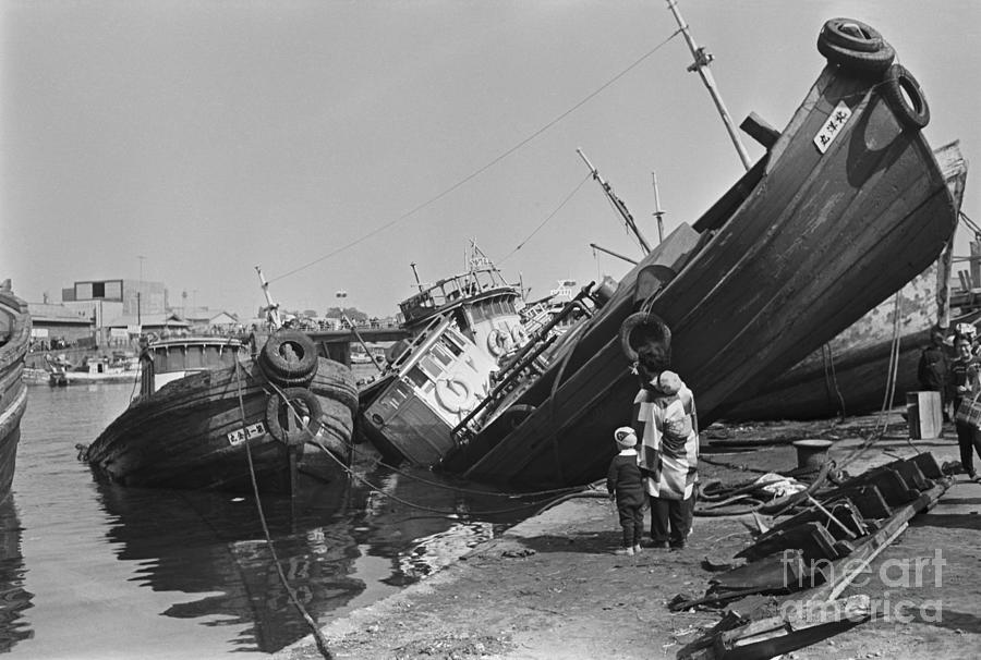 Woman And Kids Look At Ship Upturned Photograph by Bettmann