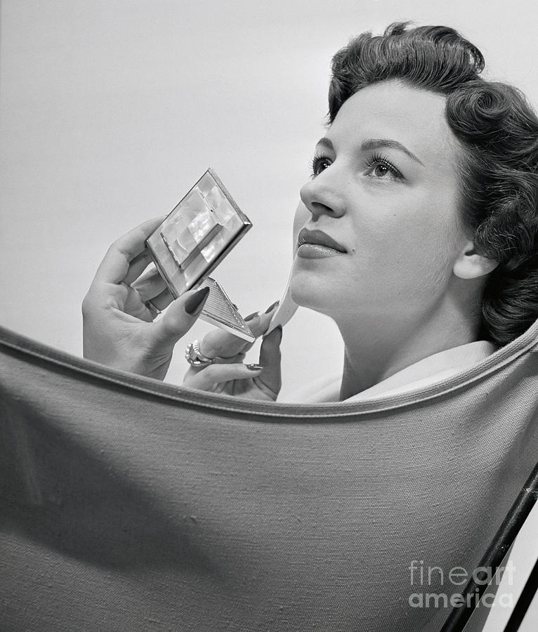 Woman Applying Makeup With A Compact Photograph by Bettmann