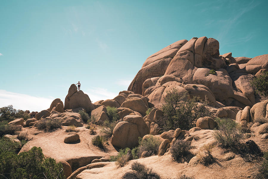 Joshua Tree National Park Photograph - Woman Climbing Rock Surreal Formation Against Blue Sky by Cavan Images