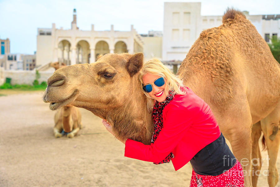Woman embraces camel Photograph by Benny Marty