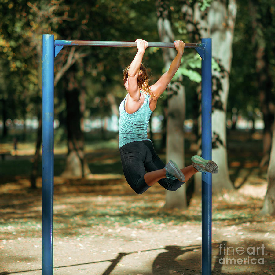 Woman Exercising On Outdoor Horizontal Bar Photograph by Microgen Images/science Photo Library