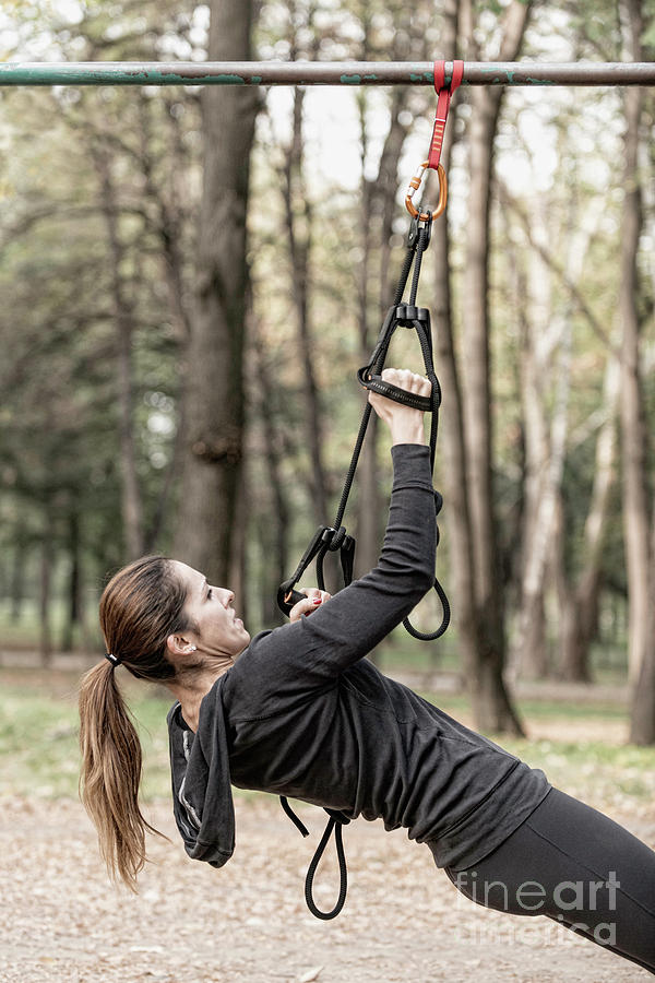 Woman Exercising With Hanging Fitness Straps Photograph by Microgen Images/science Photo Library
