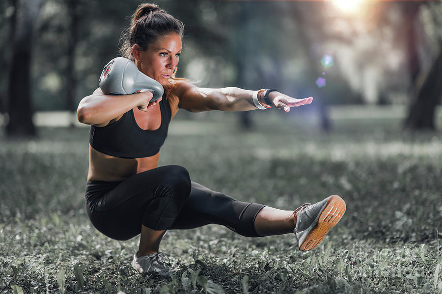 Woman Exercising With Kettlebell Outdoors Photograph by Microgen Images/science Photo Library
