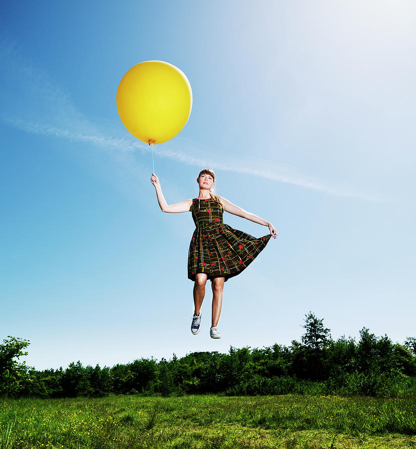 Woman Flying Holding A Big Balloon Photograph by Henrik Sorensen