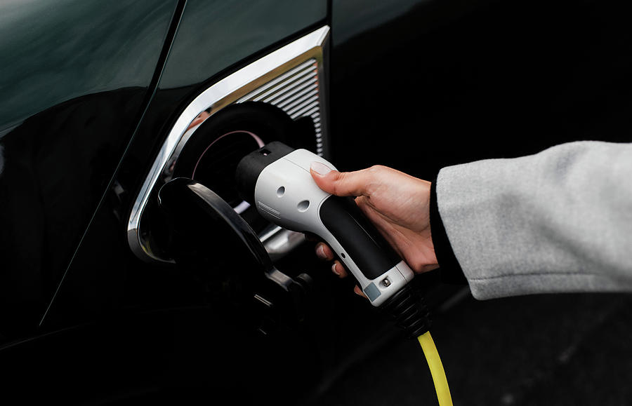 Transportation Photograph - Woman Hand And Socket Plugging In An Electric Car by Cavan Images