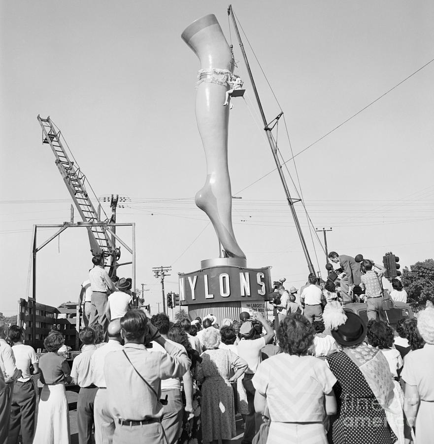 Woman Hoisted Next To A Giant Plaster Photograph by Bettmann