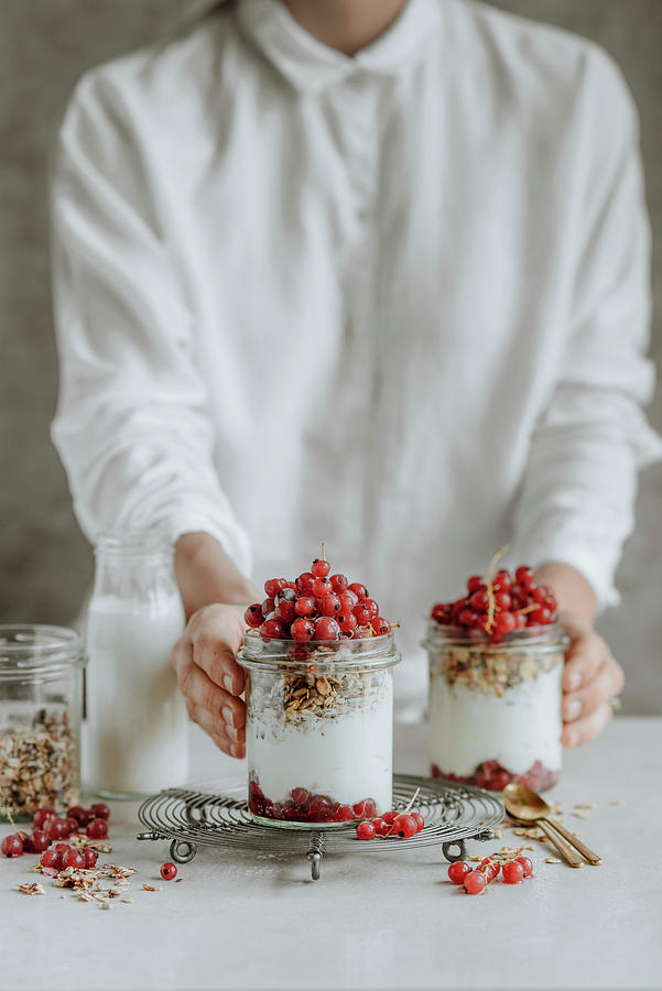 Woman Holding A Jar Of Granola Yogurt With Red Currants Photograph by Kasia Wala