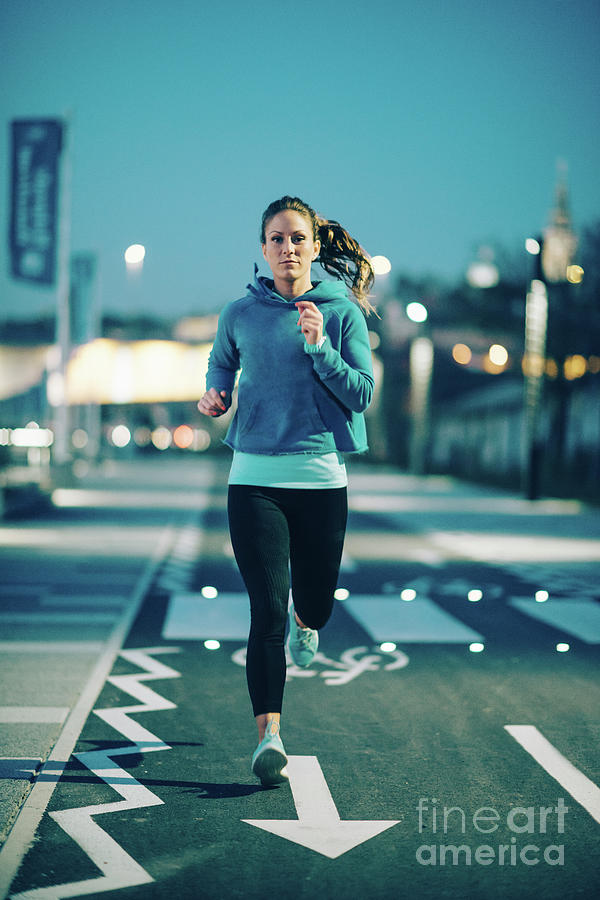 Woman Jogging In City At Night by Microgen Images/science Photo Library