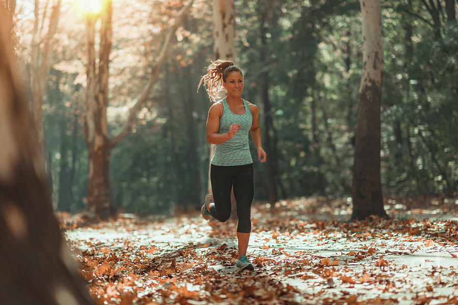 Woman Jogging Outdoors In Autumn Photograph by Microgen Images/science Photo Library