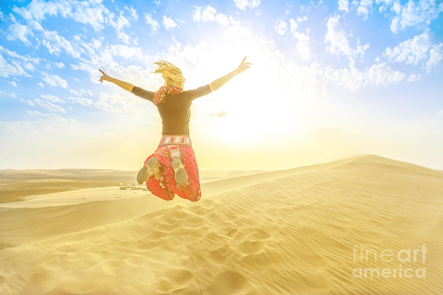 Woman jumping in Qatar desert Photograph by Benny Marty
