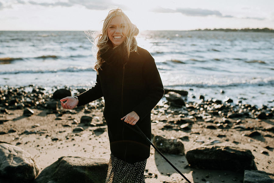 Woman Laughing On The Beach In Wintertime Photograph by Cavan Images ...