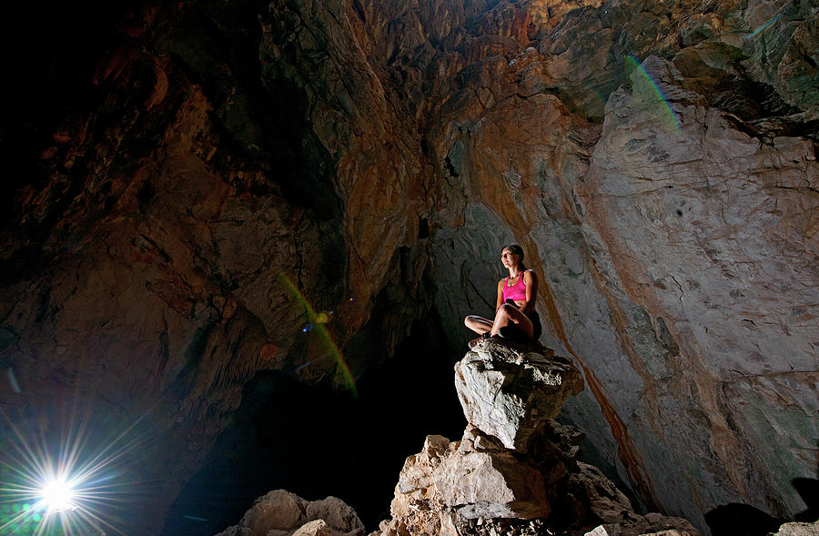 Cave Photograph - Woman Meditating At The Anxiety State Crisis Cave At Crazy Horse by Cavan Images