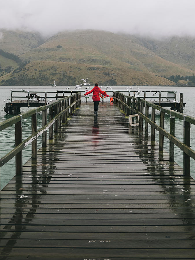 Tree Photograph - Woman On A Red Jacket Happily Running At Port Levy Jetty, Nz by Cavan Images