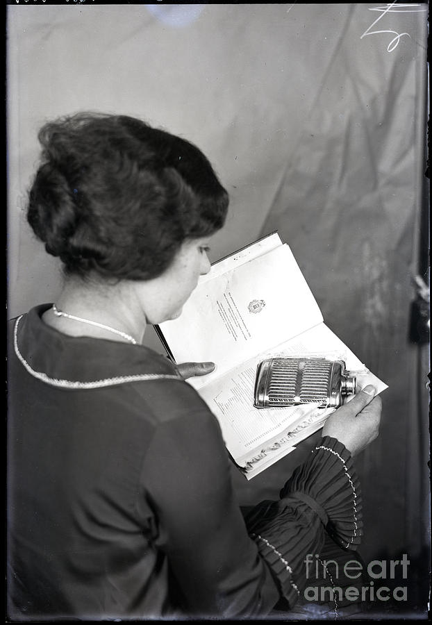 Woman Opening Book Containing Flask Photograph by Bettmann