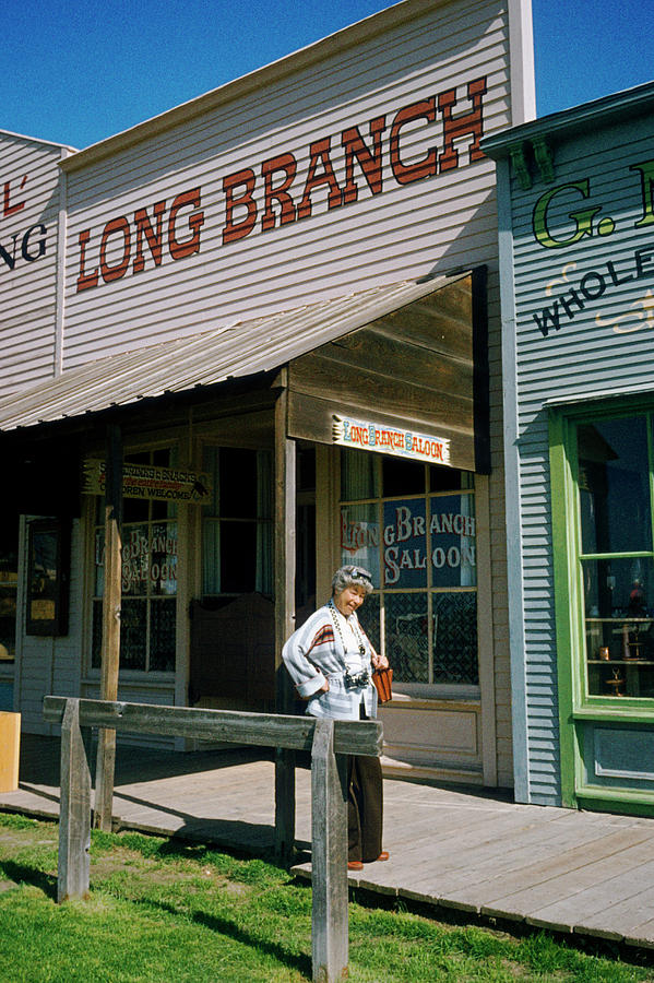 Woman outside a Long Brach saloon bar in Dodge city, Kansas - KANS505 00115  Photograph by Kevin Russell - Fine Art America
