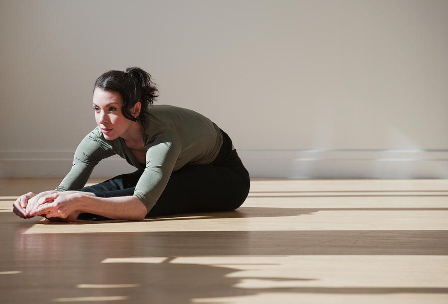 Woman Performing Stretching Exercise Photograph by Tetra Images