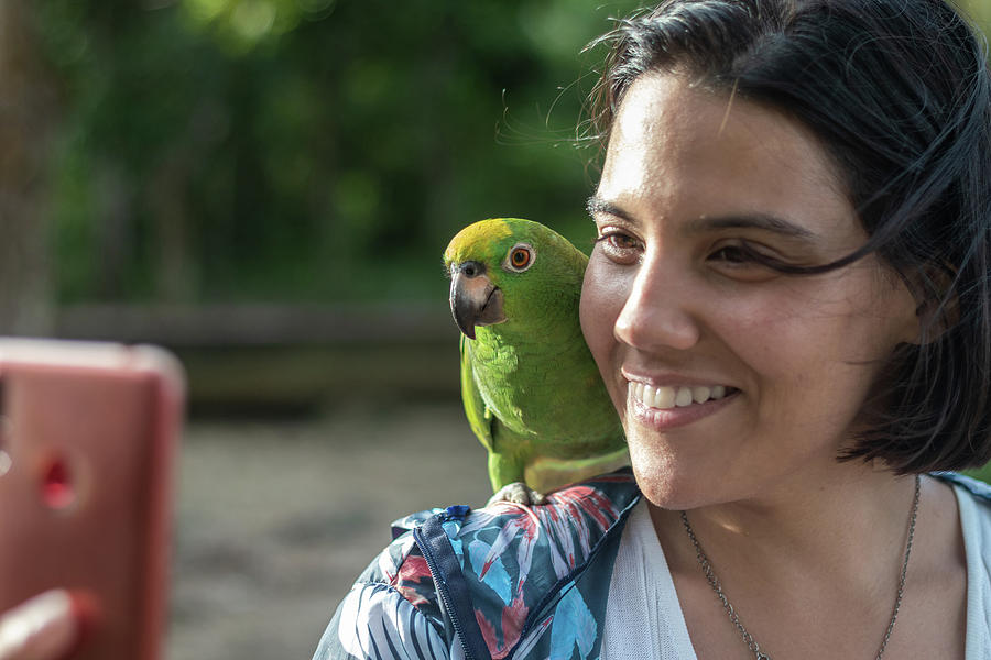 Summer Photograph - Woman Performs A Selfie With A Parrot In The Jungle Of The Orinoco Delta In Venezuela by Cavan Images