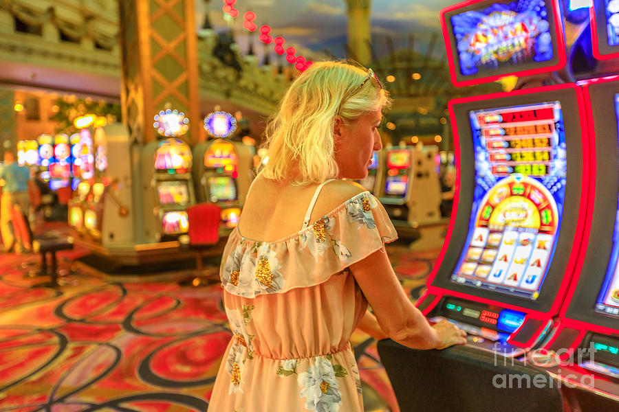 Woman plays slot machines Photograph by Benny Marty