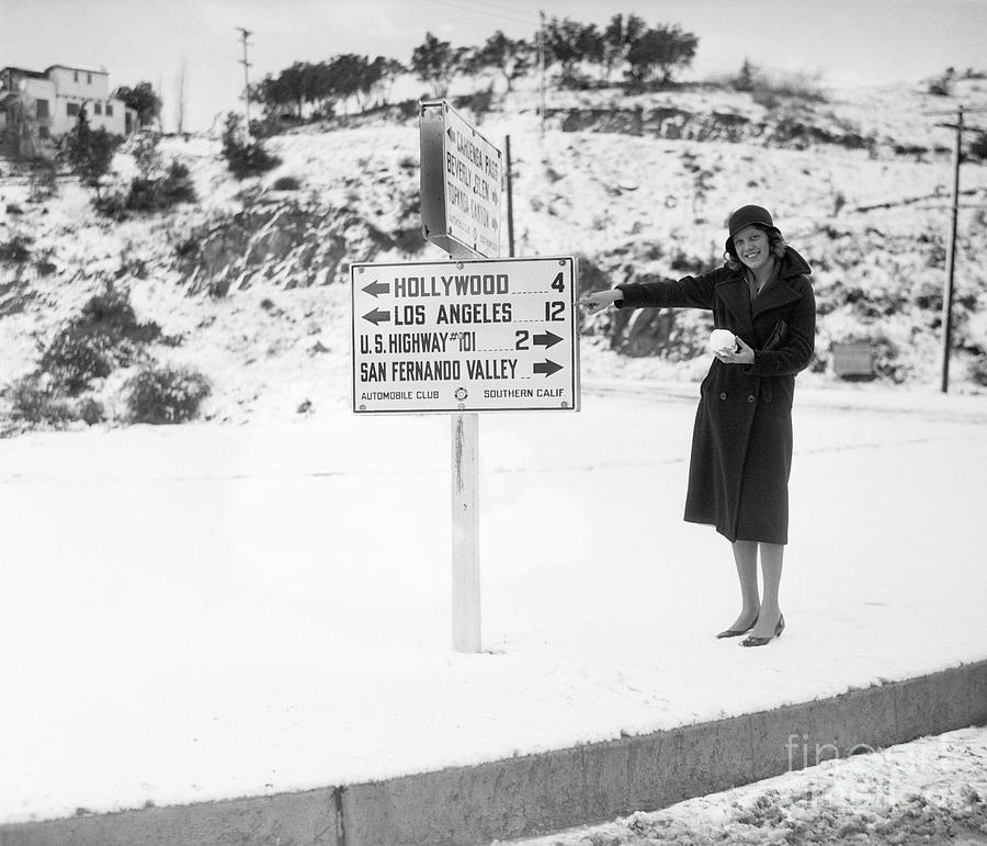 Woman Pointing To Sign In Snowy Photograph by Bettmann