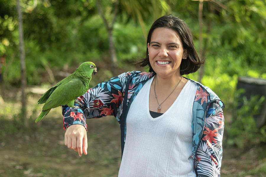 Summer Photograph - Woman Poses With A Smile As She Carries Her Arm To A Macaw In A Camp by Cavan Images