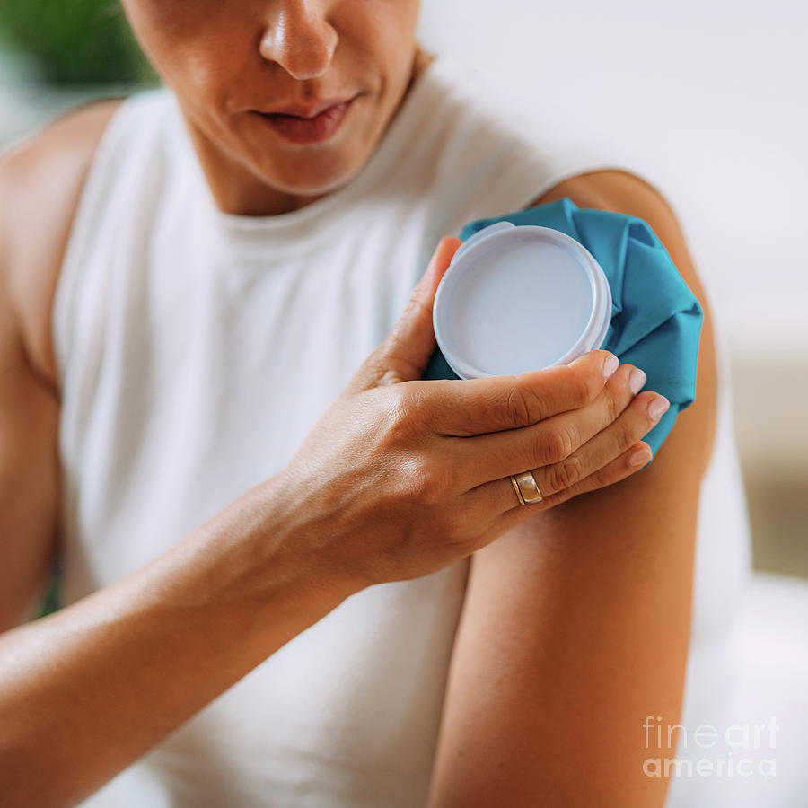 Woman Pressing Cold Compress To Shoulder Photograph by Microgen Images/science Photo Library