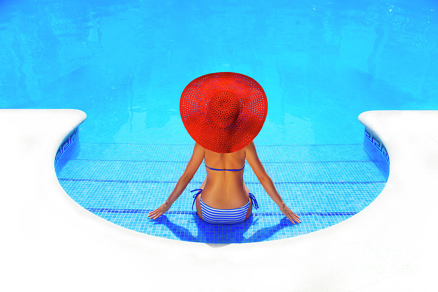 Woman Relaxing In A Resort Swimming Pool Photograph by Vladgans