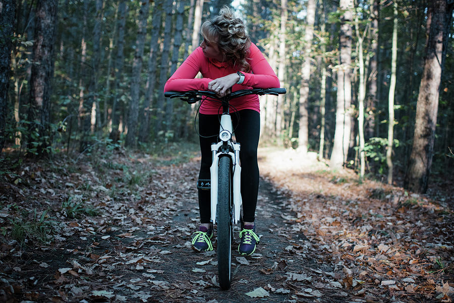 Tree Photograph - Woman Sitting On Mountain Bike Against Trees In Forest by Cavan Images
