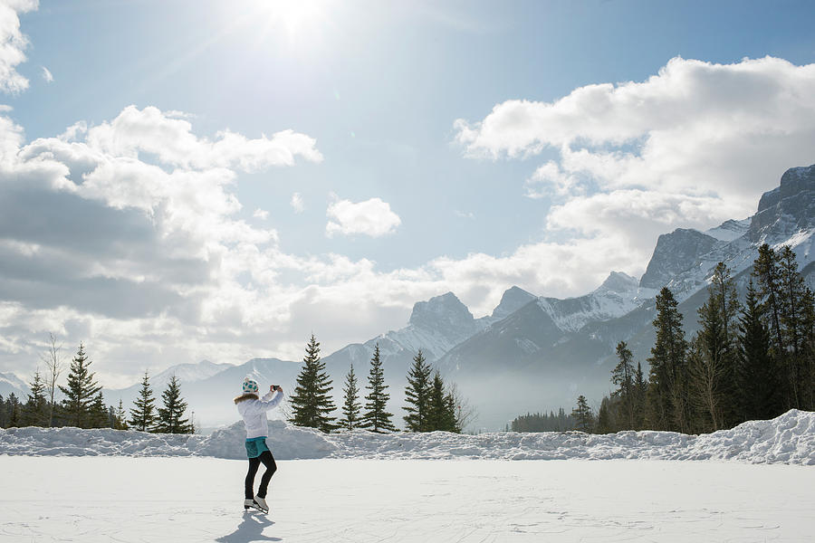 Woman Skates On Frozen Pond Under Snowy Photograph by Ascent Xmedia