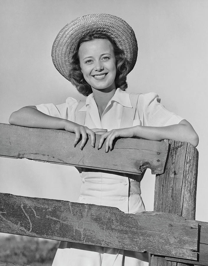Woman Smiling While Leaning On A Wooden Photograph by George Marks