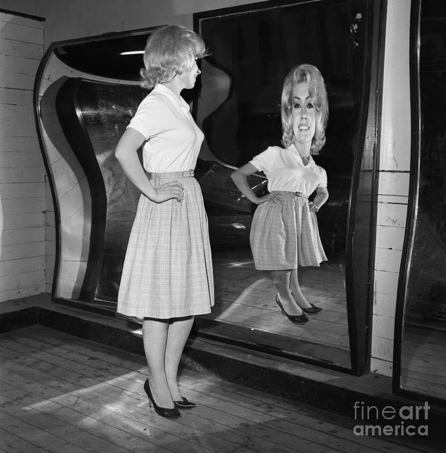 Woman Standing At Fun House Mirror Photograph by Bettmann