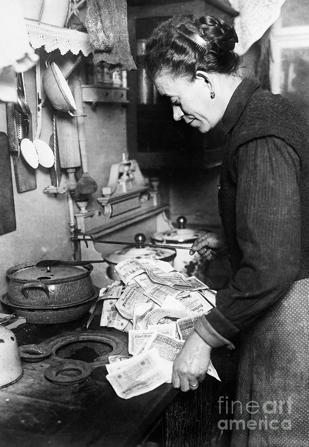 Woman Using Paper Money To Light Stove Photograph by Bettmann