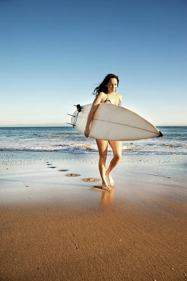 Nature Photograph - Woman Walking With Surfboard On Shore At Beach by Cavan Images