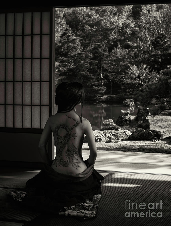 Woman with her kimono lowered revealing her naked back with a dr ...