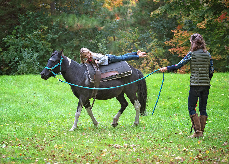 Woman With Pony On A Lead Line Carrying A Young Blond Girl Balancing. Photograph by Cavan Images