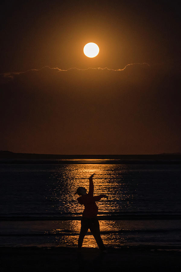 Sunset Photograph - Women Strikes A Pose Silhouetted Against Harvest Moon Highlights by Cavan Images