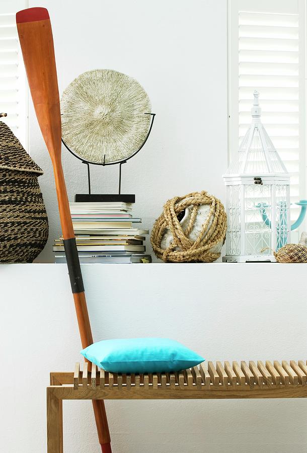 Wooden Bench & Paddle In Front Of Various Ornaments On Masonry Shelf Photograph by Matteo Manduzio
