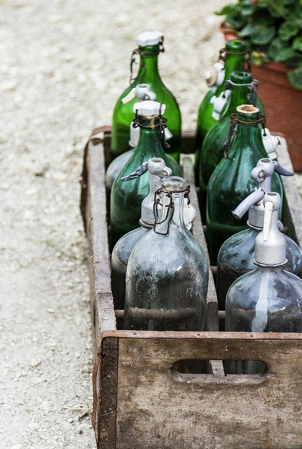 Wooden Crate Of Empty Bottles On Garden Path Photograph by Adel Bekefi