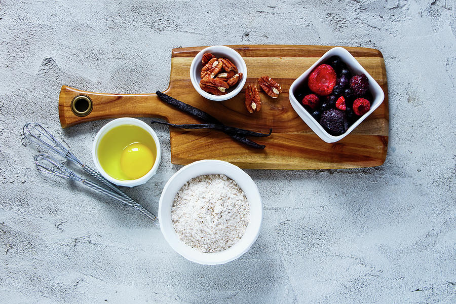 Wooden Cutting Board With Ingredients For Baking whole Flour, Egg, Frozen Berries, Nuts And Vanilla Over Concrete Textured Background Photograph by Yuliya Gontar