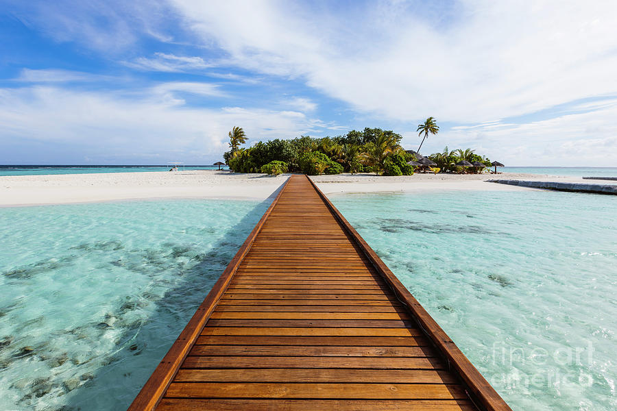 Wooden jetty to a tropical island, Maldives Photograph by Matteo Colombo
