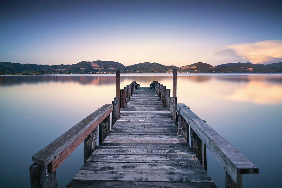 Wooden pier or jetty on a blue lake sunset and sky reflection on Photograph by Stefano Orazzini
