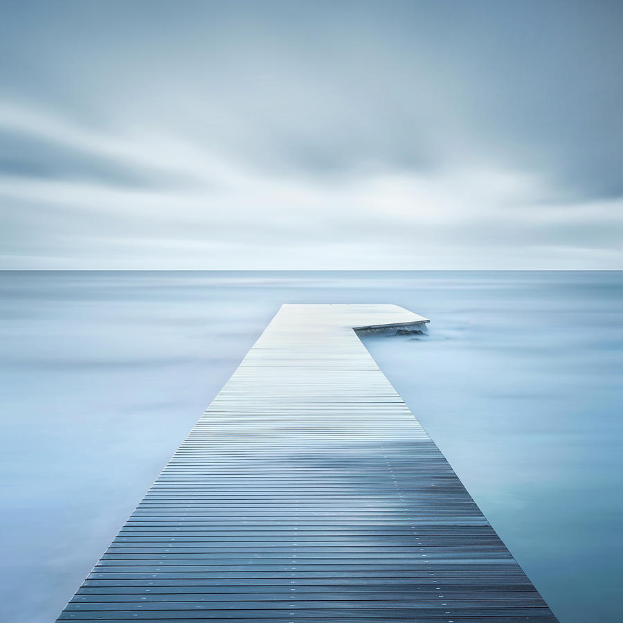 Wooden pier, rocks and calm sea on long exposure. Photograph by Stefano Orazzini