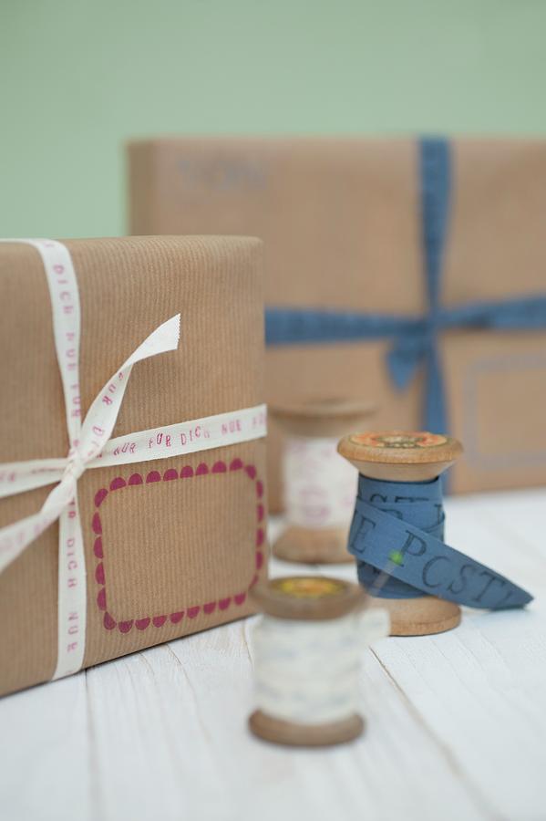 Wooden Reels And Simply Wrapped Packages With Ribbons Photograph by Studio27neun
