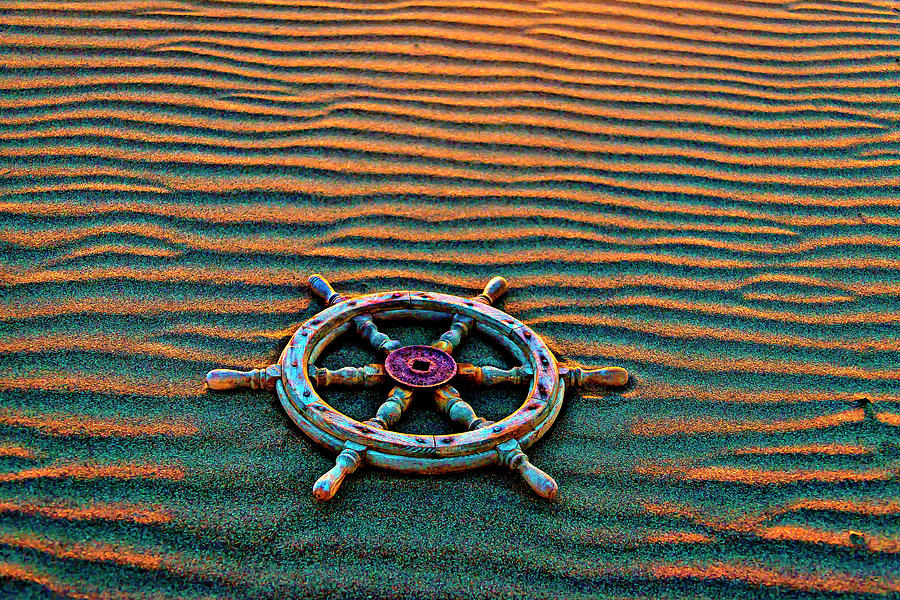 Wooden Ships Wheel On Wavey Sand Photograph by Garry Gay