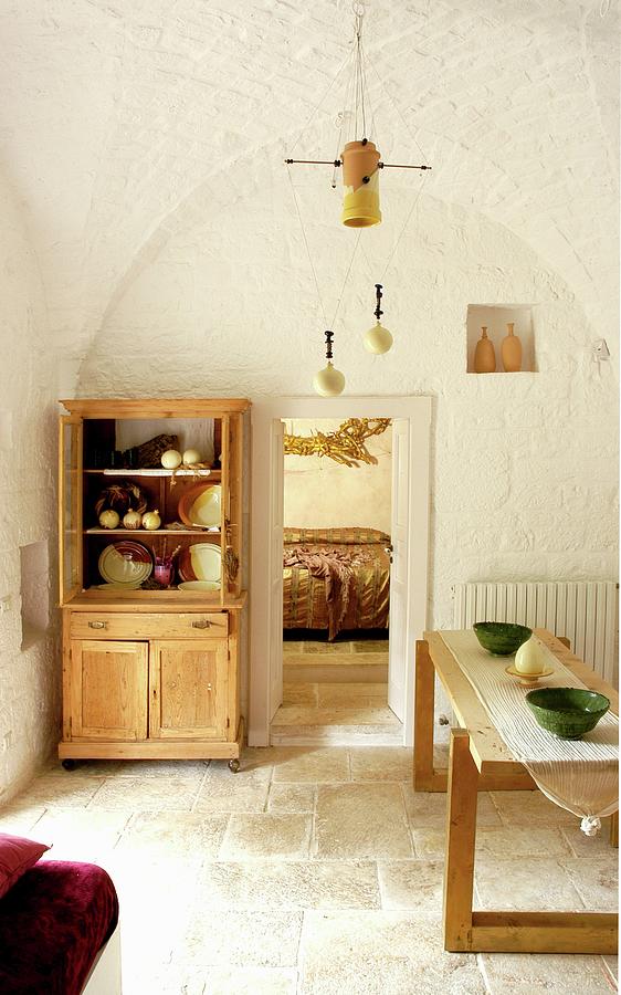 Wooden Table And Dresser Against Whitewashed Walls In Renovated Trullo Photograph by Michele Mulas