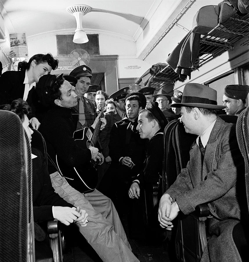 Woody Guthrie Playing Guitar On Train Photograph by Eric Schaal