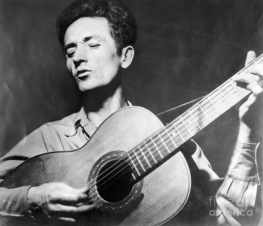 Woody Guthrie Playing The Guitar Photograph by Bettmann