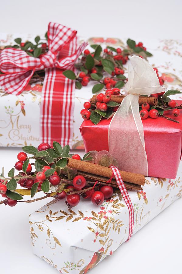 Wrapped Christmas Gifts Decorated With Ribbons, Rosehips And Cinnamon Sticks Photograph by Linda Burgess