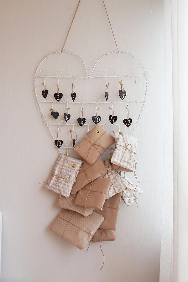Wrapped Gifts Hung From Wire Heart As Advent Calendar Photograph by Camilla Isaksson