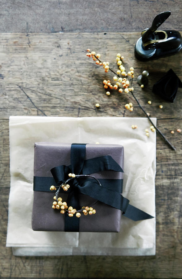 Wrapped Present Decorated With Sprig Of Berries Photograph by Nicoline Olsen