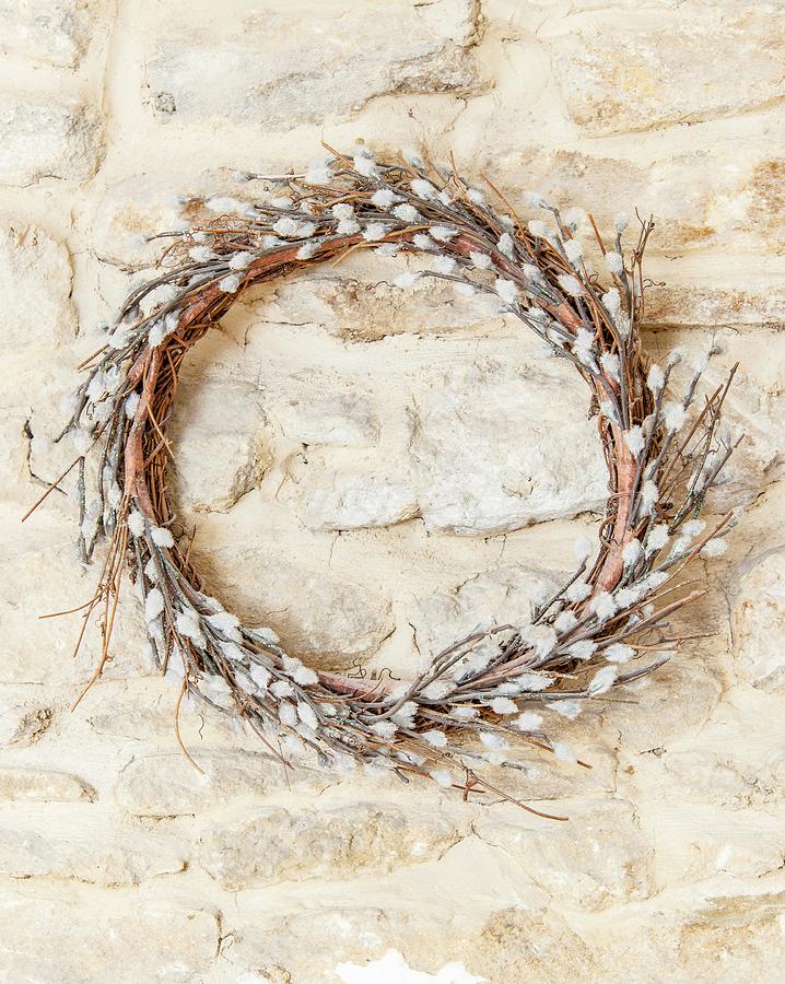 Wreath Of Artificial Willow Catkins Hung On Stone Wall Photograph by Stuart Cox